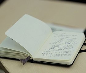 Photo of notebook with handwritten notes inside.